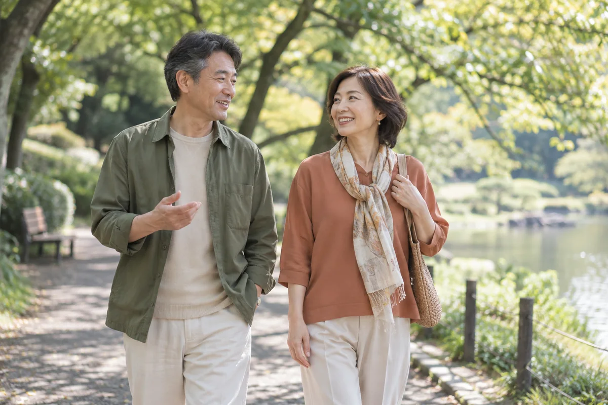 公園を並んで歩き穏やかな時間を楽しむ50代のカップル