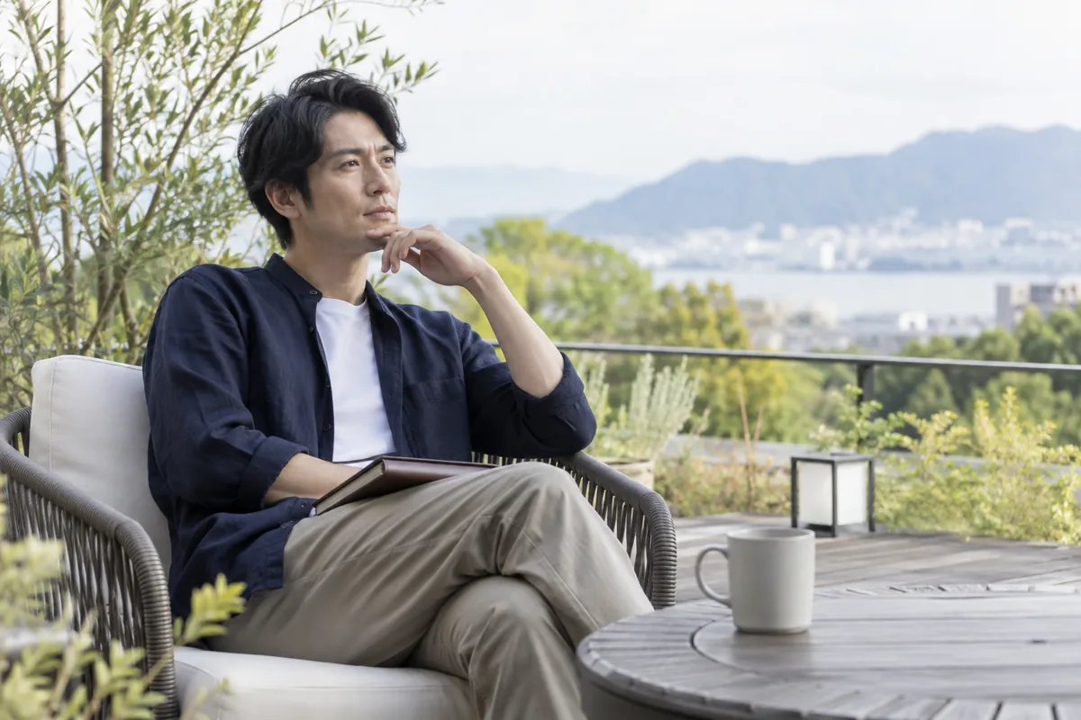 静かなテラスで恋人との出来事を落ち着いて考える男性