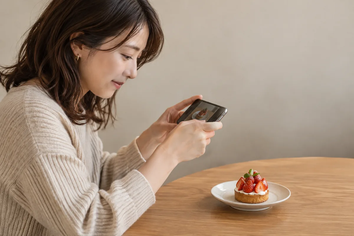 場所や人を写さずカフェのデザートを撮る女性