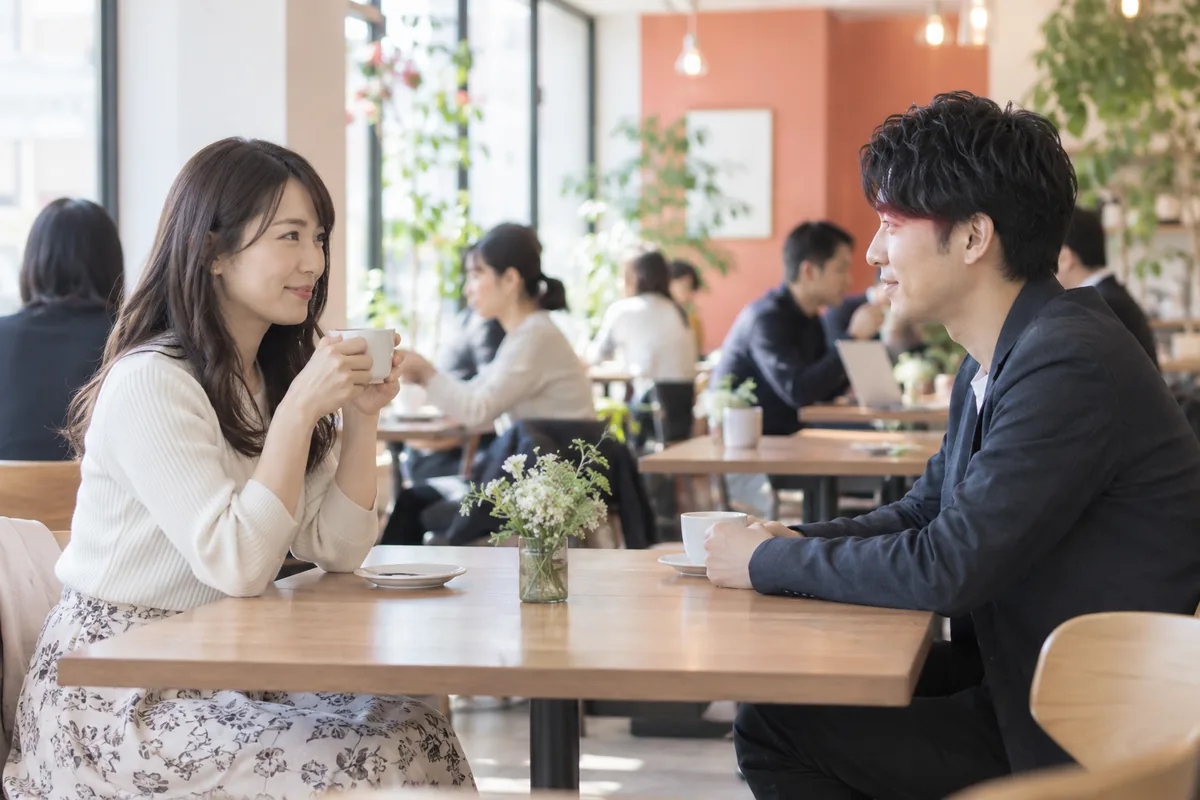人のいる明るいカフェで距離を保って初めて会う二人