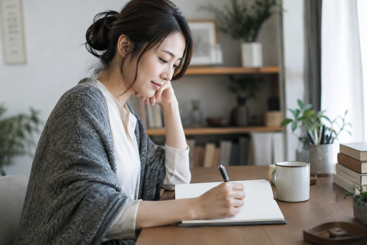 相談に必要な自分の情報をノートで確認する女性のイメージ