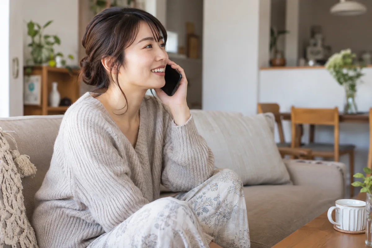 自宅で落ち着いて電話をする女性のイメージ