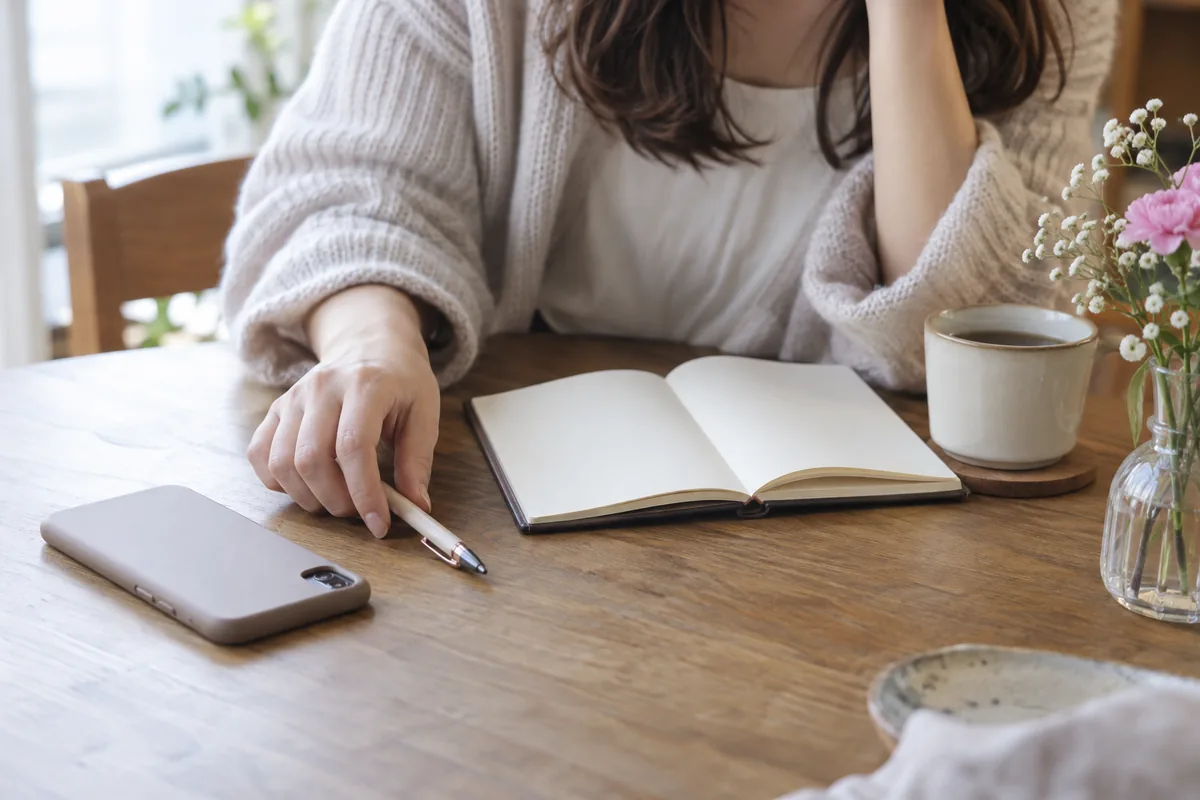 白紙のノートとペンで伝えたい言葉を整理する机のイメージ
