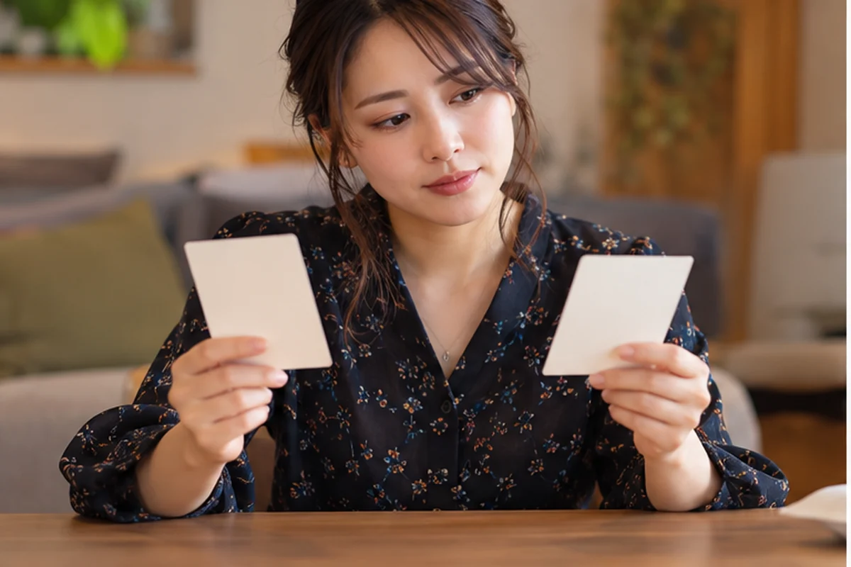スマートフォンを自分に向けてコメットの鑑定料金を確認する女性