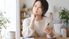 出会いサービスを使う前にスマートフォンで考える女性