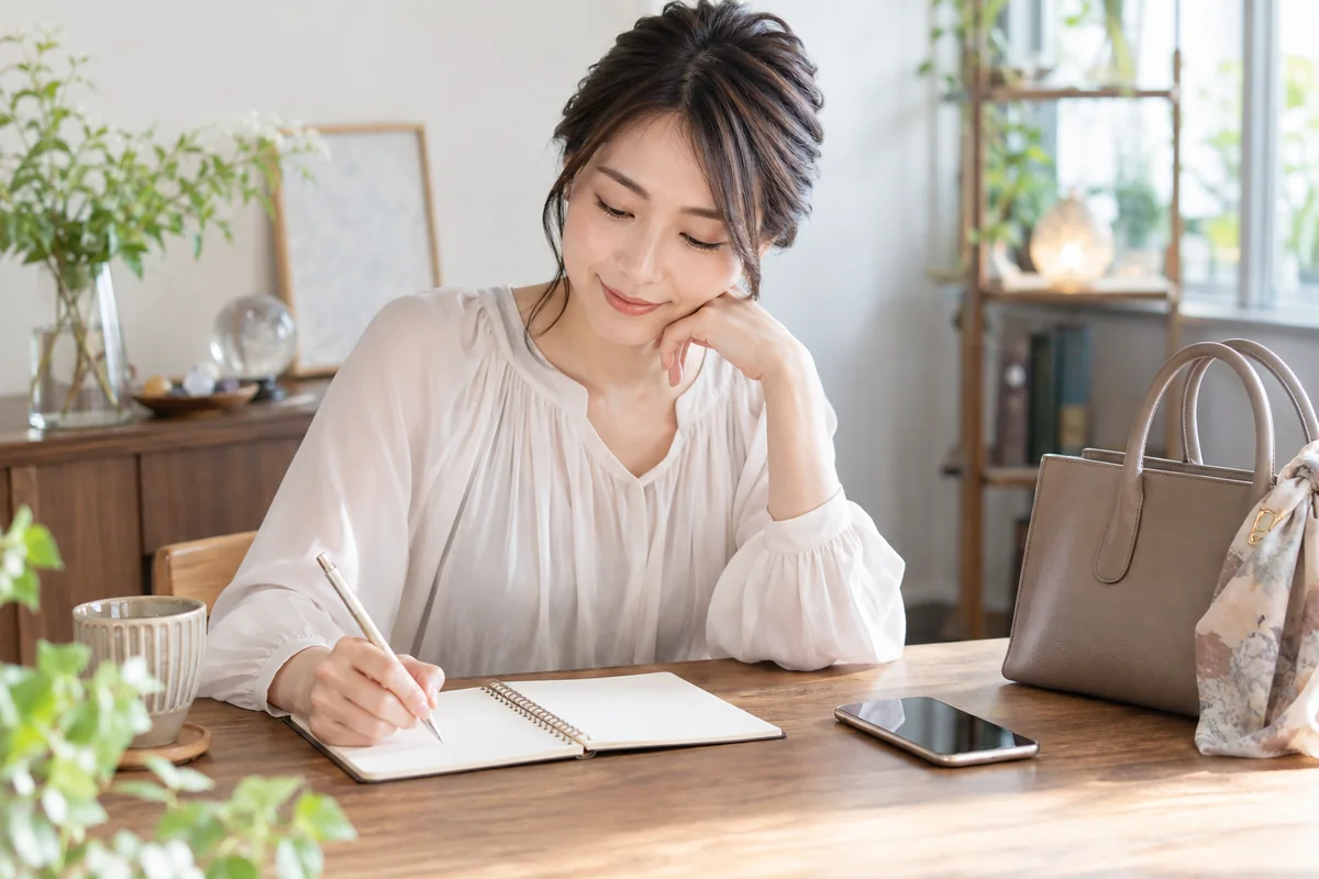 初めての鑑定前に質問したい内容をノートへ整理する女性
